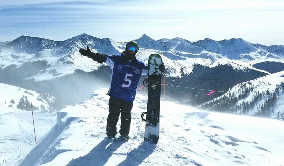 Snowboarder on mountain with board.